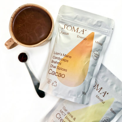 SOMA energy drink mix packets with a cup of hot chocolate on a white background